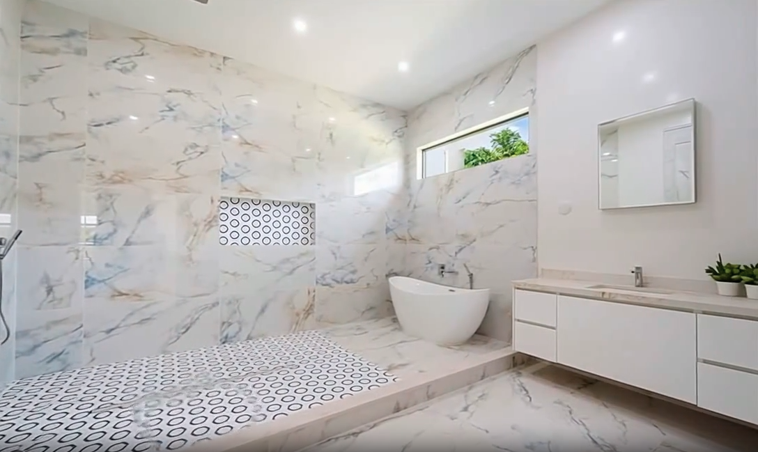 Modern master bathroom with marble tile and freestanding tub - luxury bathroom remodel Naples FL